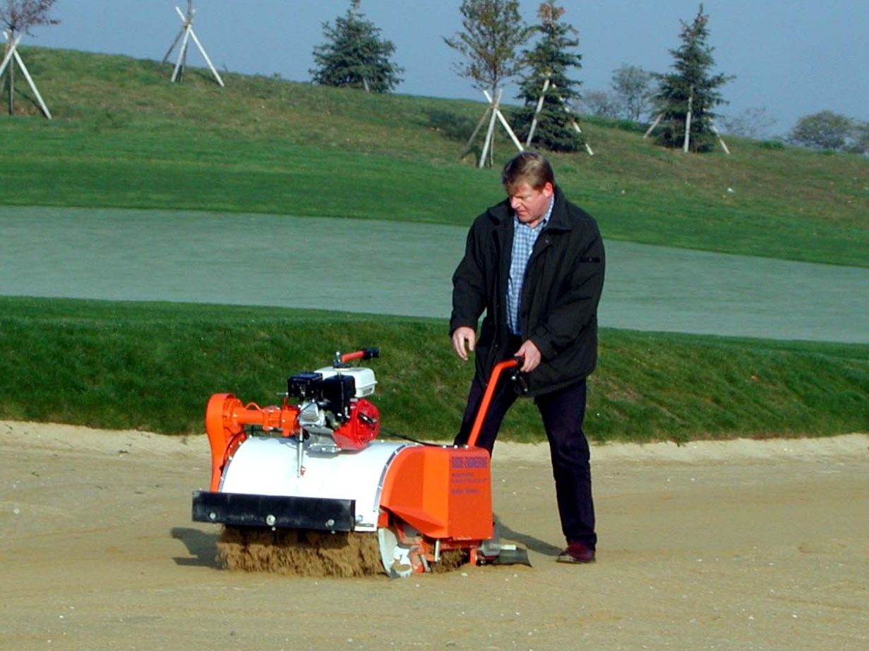 Sandreiniger BC1000 bei der Bunker Reinigung auf dem Golfplatz.. Sandreinigung in einem Sandbunker mit dem Sandreiniger BC1000 auf dem Golfplatz.